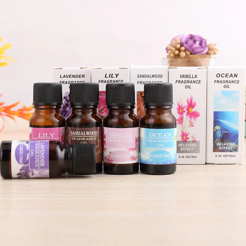 Set of fragrance oil bottles with labels on a wooden surface