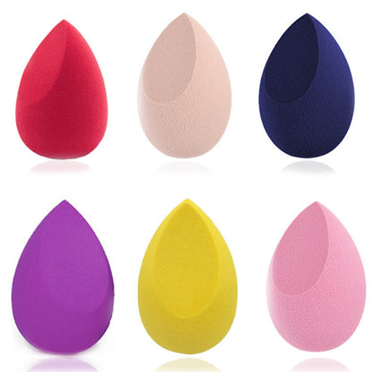 Set of six colorful teardrop makeup sponges in red, beige, navy, purple, yellow, and pink on white background