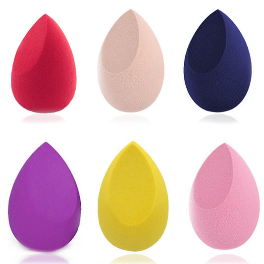 Set of six colorful teardrop makeup sponges in red, beige, navy, purple, yellow, and pink on white background