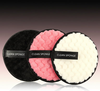 Set of three round clean sponges in black, pink, and white with textured surfaces