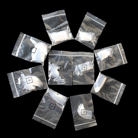 Clear sealed plastic bags arranged in a circle on black background, each containing white nail tips labeled with numbers