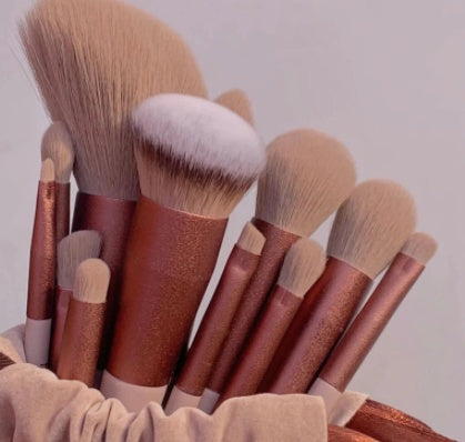 Set of soft makeup brushes with rose gold handles in a beige holder