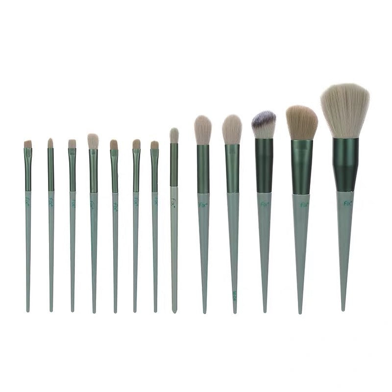 Set of twelve green-handled makeup brushes with various brush head shapes and sizes on white background