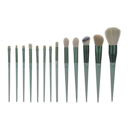 Set of twelve green-handled makeup brushes with various brush head shapes and sizes on white background