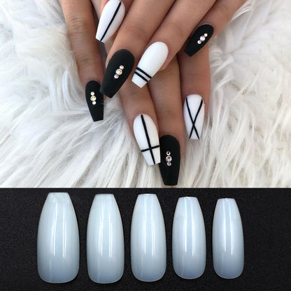 Black and white long coffin nails with geometric line art and rhinestone accents on white fur background