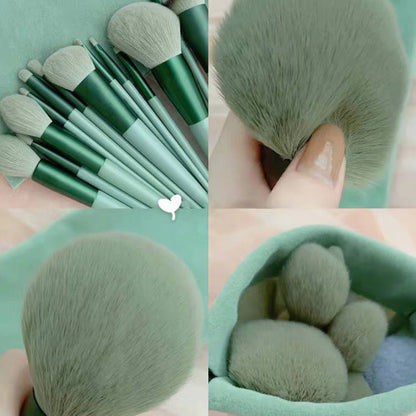 Set of soft green makeup brushes with different shapes and sizes on matching fabric background