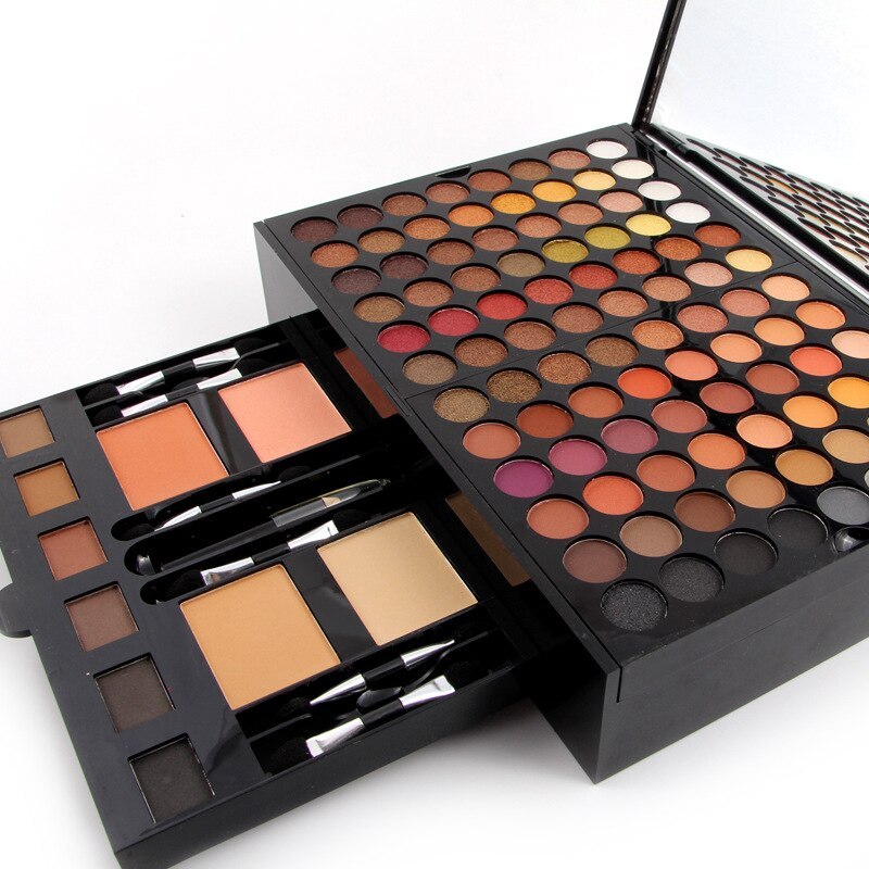Makeup palette featuring diverse eyeshadows and face powders with applicators in a black case