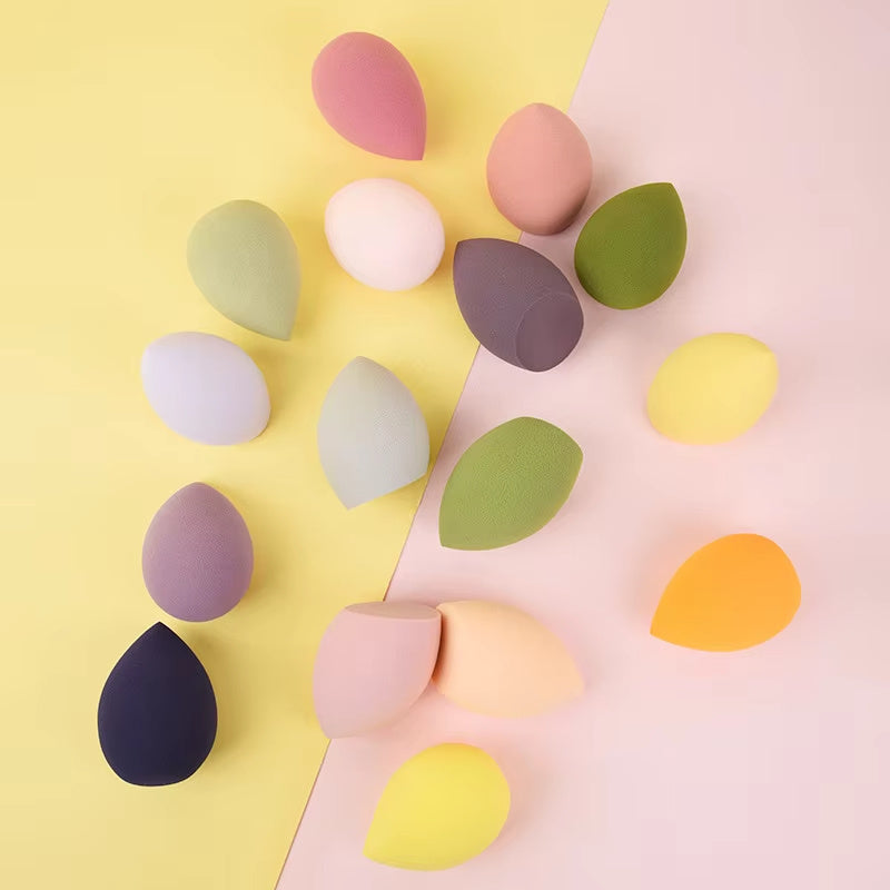 Multicolor makeup blending sponges arranged on pastel yellow and pink backgrounds